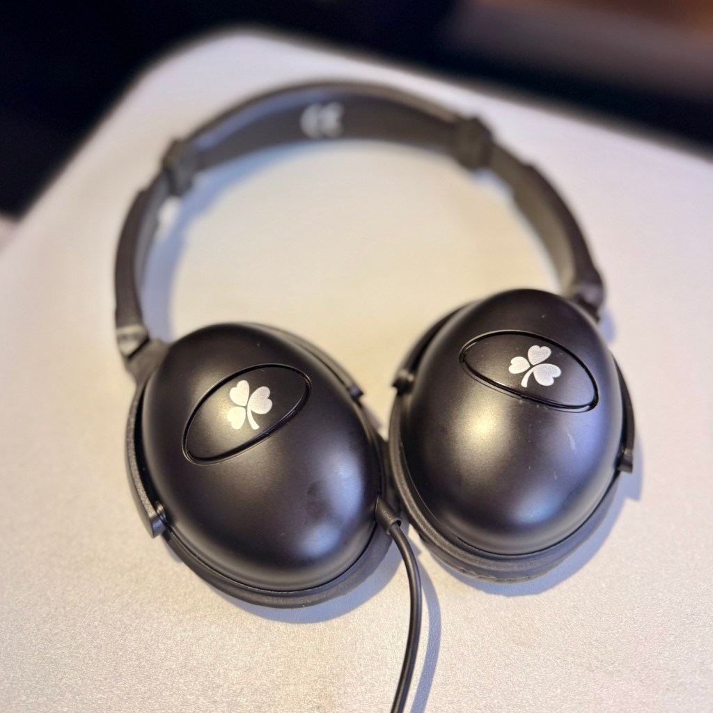 Close-up of Aer Lingus branded headphones resting on a tray table.