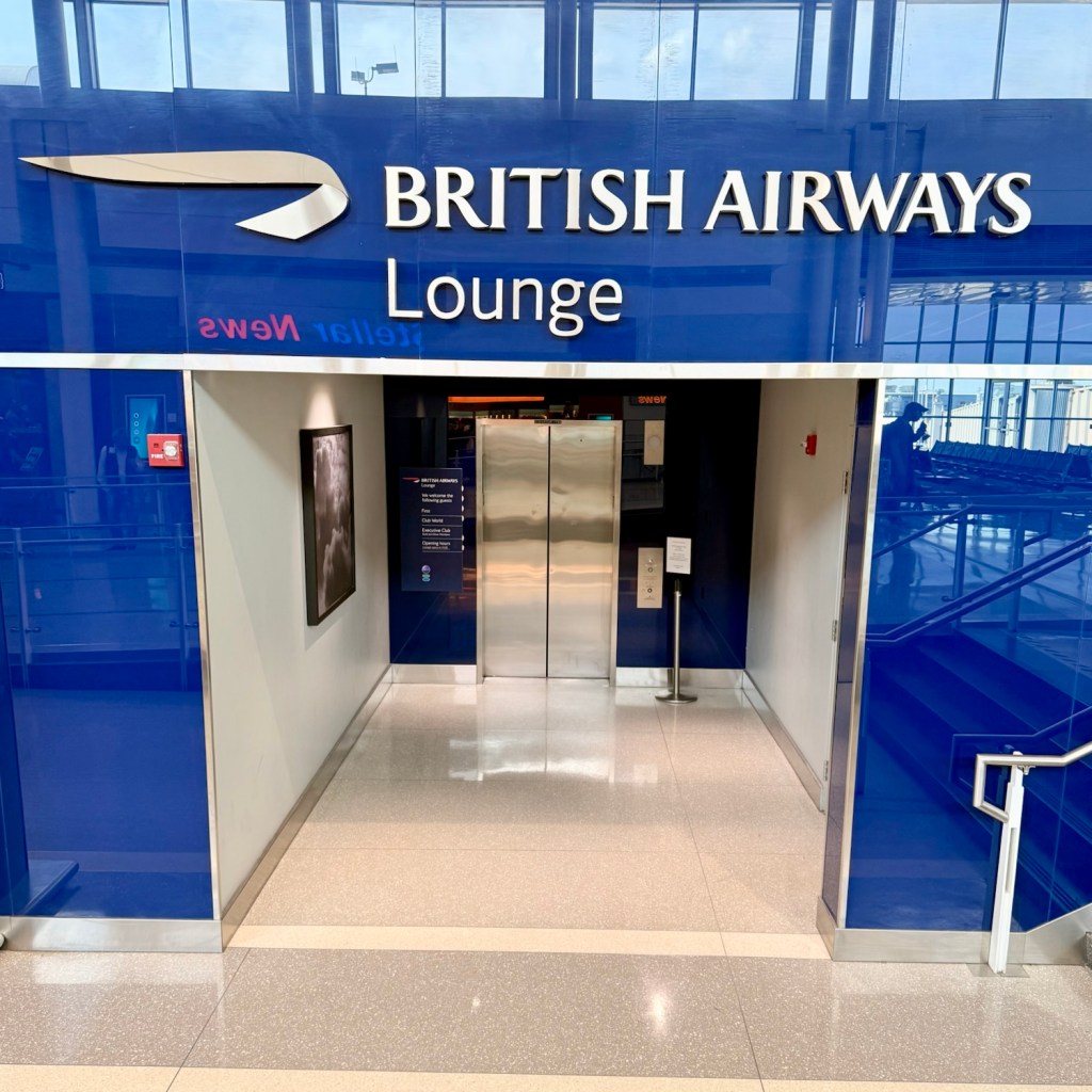 Entrance to the British Airways Lounge featuring a large sign and elevator access.
