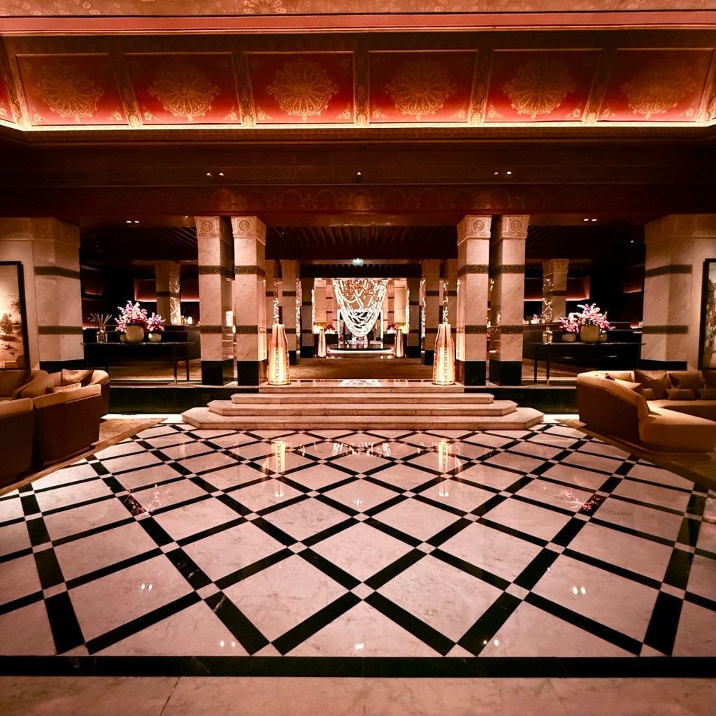 Opulent hotel lobby of La Mamounia in Marrakech, showcasing intricate marble flooring, elegant columns, and luxurious furnishings.