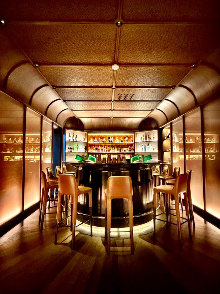 Interior view of the Churchill Bar at La Mamounia, featuring a circular bar surrounded by high stools and warm lighting, highlighting a luxurious and intimate atmosphere.