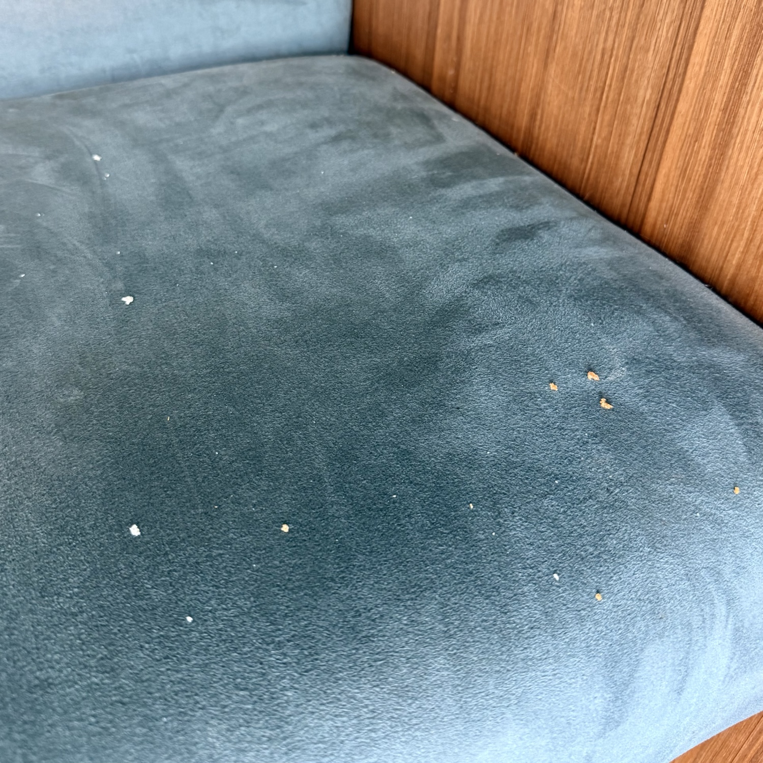 Close-up view of a dirty cushion in an airport lounge, showing crumbs and debris on the surface.