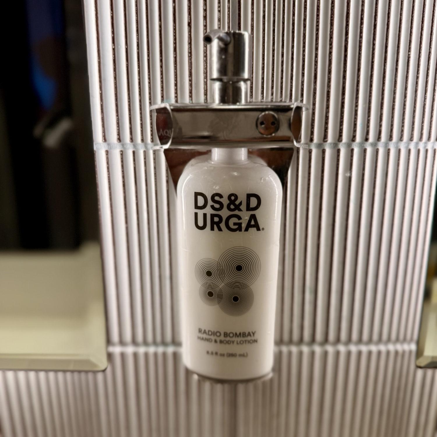 A bottle of DS&D Urga Radio Bombay hand and body lotion displayed against a sleek, modern background.