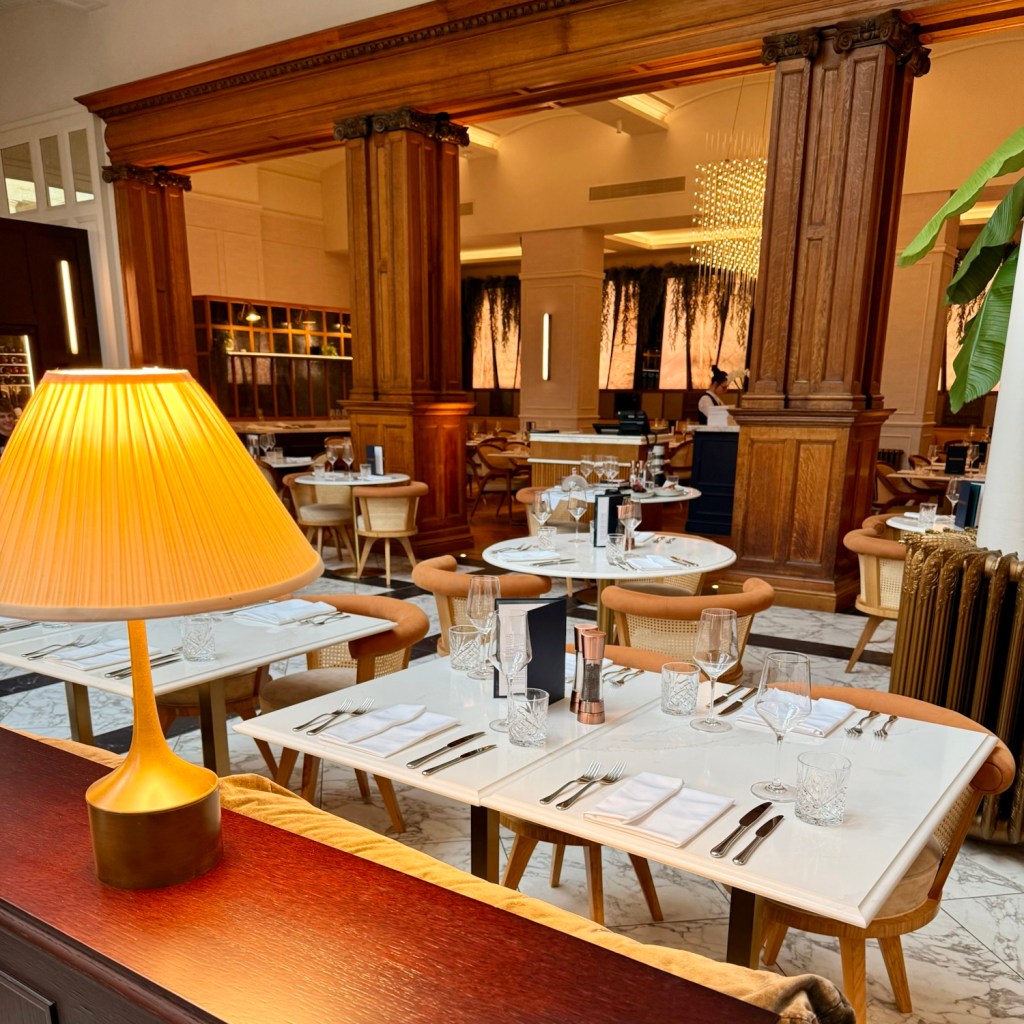 Interior view of the restaurant in the Municipal Hotel Liverpool, featuring elegantly set tables, modern decor, and wooden architectural details.
